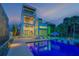 Stunning modern home with a pool, outdoor kitchen, and balconies at dusk at 1194 N Peninsula, New Smyrna Beach, FL 32169