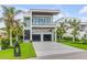 Beautiful modern home with lush green grass, sleek driveway, and tropical landscaping at 1194 N Peninsula, New Smyrna Beach, FL 32169