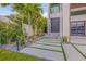 Modern home's front walkway with decorative stones and lush plants leads to a stylish entrance at 1194 N Peninsula, New Smyrna Beach, FL 32169