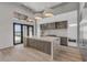 A modern kitchen features white and wood cabinets, marble counters and backsplash, pendant lighting, and outside access at 1194 N Peninsula, New Smyrna Beach, FL 32169