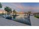 Stunning waterfront infinity pool with lounge chairs, fire feature, and picturesque sunset views over the water at 1194 N Peninsula, New Smyrna Beach, FL 32169