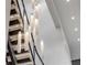 Close-up of staircase with modern chandelier featuring unique vertical lights at 1194 N Peninsula, New Smyrna Beach, FL 32169