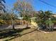 Landscaped backyard featuring a pergola-covered seating area, palms and colorful plants at 1208 Pat Ave, New Smyrna Beach, FL 32168