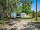 A storage shed in the back yard with a large tree at 1208 Pat Ave, New Smyrna Beach, FL 32168