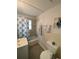 Bright bathroom with decorative tile accents, shower with curtain, and a seashell wall art piece at 1208 Pat Ave, New Smyrna Beach, FL 32168