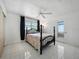 This bedroom offers a ceiling fan, tile flooring, and a bed with black frame at 1208 Pat Ave, New Smyrna Beach, FL 32168