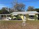 Inviting yellow house with a quaint front yard, white trim, and a welcoming pathway to the front door at 1208 Pat Ave, New Smyrna Beach, FL 32168