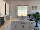 Well-lit kitchen features a double basin sink, white cabinets, and a window at 1208 Pat Ave, New Smyrna Beach, FL 32168