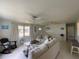 Bright living room with white sofas, bright windows, ceiling fans and coastal decor at 1208 Pat Ave, New Smyrna Beach, FL 32168