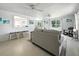 Bright living room with light wood floors, cozy seating, and views through large windows at 1208 Pat Ave, New Smyrna Beach, FL 32168