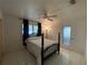 This main bedroom is fitted with tiled floors, a ceiling fan, and a black four-poster bed at 1208 Pat Ave, New Smyrna Beach, FL 32168