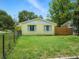 A view of the fenced in front yard, with a mature shade tree at 1208 Pat Ave, New Smyrna Beach, FL 32168