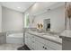 This bathroom features dual sinks, white cabinets, granite countertops, and a tub at 1290 9Th St, Orange City, FL 32763