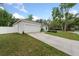 White two-car garage and long driveway surrounded by a well-manicured lawn and beautiful landscaping at 1290 9Th St, Orange City, FL 32763