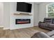 Cozy living room with electric fireplace, wall-mounted television, and hardwood floors at 1290 9Th St, Orange City, FL 32763