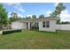Inviting single-story home with lush green lawn, white privacy fence, and a charming landscaped garden at 1290 9Th St, Orange City, FL 32763
