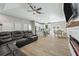 Spacious living room with dark leather sofa, wood floors, ceiling fan and open to kitchen at 1290 9Th St, Orange City, FL 32763