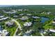 An aerial view of a community with lush greenery, a pond, and multi-Gathering homes near a beach at 135 Cedar Dunes Dr, New Smyrna Beach, FL 32169