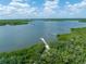 Stunning aerial view of a waterfront dock surrounded by lush greenery and sparkling blue waters at 135 Cedar Dunes Dr, New Smyrna Beach, FL 32169