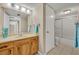 Bathroom features a vanity with a large mirror and a shower-tub combination with sliding glass doors at 135 Cedar Dunes Dr, New Smyrna Beach, FL 32169