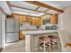 The kitchen features sleek stainless steel appliances, wood cabinets, a breakfast bar, and stylish tile floors at 135 Cedar Dunes Dr, New Smyrna Beach, FL 32169
