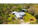 Aerial view of a beautiful home with a metal roof, an enclosed pool, and lush landscaping at 1370 Jane Lacey Ln, New Smyrna Beach, FL 32168