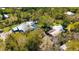 Aerial view of the house with screened pool, carport, storage shed, and surrounded by lush trees at 1370 Jane Lacey Ln, New Smyrna Beach, FL 32168