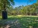 Large, grassy backyard features mature trees and shaded areas, offering a serene space for outdoor activities at 1370 Jane Lacey Ln, New Smyrna Beach, FL 32168