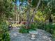 Backyard brick patio with lush landscaping, a tree house, and an outdoor dining area for gatherings at 1370 Jane Lacey Ln, New Smyrna Beach, FL 32168
