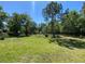 Sprawling backyard with lush green grass, mature trees, and a split rail fence at 1370 Jane Lacey Ln, New Smyrna Beach, FL 32168