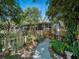 A charming backyard with a winding pathway, lush greenery, and a cozy fenced-in area at 1370 Jane Lacey Ln, New Smyrna Beach, FL 32168