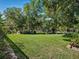 Expansive green backyard features a lush lawn, mature trees, and landscaped borders perfect for outdoor enjoyment at 1370 Jane Lacey Ln, New Smyrna Beach, FL 32168