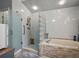Bathroom showcasing walk-in shower and a soaking tub with a glass block partition at 1370 Jane Lacey Ln, New Smyrna Beach, FL 32168