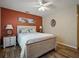 Comfortable bedroom features a ceiling fan, beach themed artwork, and a cozy bed with patterned bedding at 1370 Jane Lacey Ln, New Smyrna Beach, FL 32168