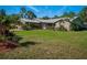 Charming single-story brick home featuring a metal roof, manicured lawn and beautifully landscaped flowerbeds at 1370 Jane Lacey Ln, New Smyrna Beach, FL 32168