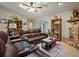 Comfortable living room featuring a stone fireplace, a leather sofa and decor at 1370 Jane Lacey Ln, New Smyrna Beach, FL 32168