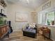 Cozy living room showcases a chaise lounge, wood-look flooring, and natural light from the window at 1370 Jane Lacey Ln, New Smyrna Beach, FL 32168