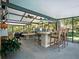 Outdoor kitchen and dining area with a bar, seating, and tropical surroundings at 1370 Jane Lacey Ln, New Smyrna Beach, FL 32168
