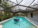 Large inground pool with waterslide and water features under screened enclosure at 1370 Jane Lacey Ln, New Smyrna Beach, FL 32168
