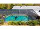 Enclosed screened-in pool with fun floaties for summer fun, surrounded by green landscaping at 1370 Jane Lacey Ln, New Smyrna Beach, FL 32168