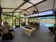 Spacious screened porch featuring an outdoor kitchen, bar seating, ceiling fans, and a cozy fire table, perfect for entertaining guests at 1370 Jane Lacey Ln, New Smyrna Beach, FL 32168