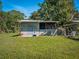 Backyard shed on green grass with a Dutch door and fenced animal pen provides country charm at 1370 Jane Lacey Ln, New Smyrna Beach, FL 32168