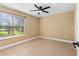 Bright bedroom featuring a ceiling fan and large window with a view at 1600 Big Tree Rd # G3, South Daytona, FL 32119