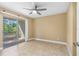 A bedroom with neutral walls, tile flooring, and a sliding glass door to the exterior at 1600 Big Tree Rd # I2, South Daytona, FL 32119