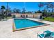 Community pool featuring lounge seating and shade trees on a sunny day at 1600 Big Tree Rd # I2, South Daytona, FL 32119