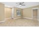 Bright living room with neutral walls, tile flooring, ceiling fan, and natural light at 1600 Big Tree Rd # I2, South Daytona, FL 32119