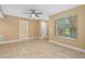 Bright living room with neutral walls, tile flooring, ceiling fan, and a large window at 1600 Big Tree Rd # I2, South Daytona, FL 32119