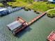 Aerial view showcasing a long dock with a covered boat lift and upper deck, nestled in a serene waterfront setting at 2019 S Riverside, Edgewater, FL 32141