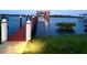 Private dock featuring a wood deck, boatlift, and lush landscaping at 2019 S Riverside, Edgewater, FL 32141