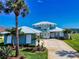 Beautiful waterfront home with attached garage, lush landscaping, and mature palm trees at 2019 S Riverside, Edgewater, FL 32141